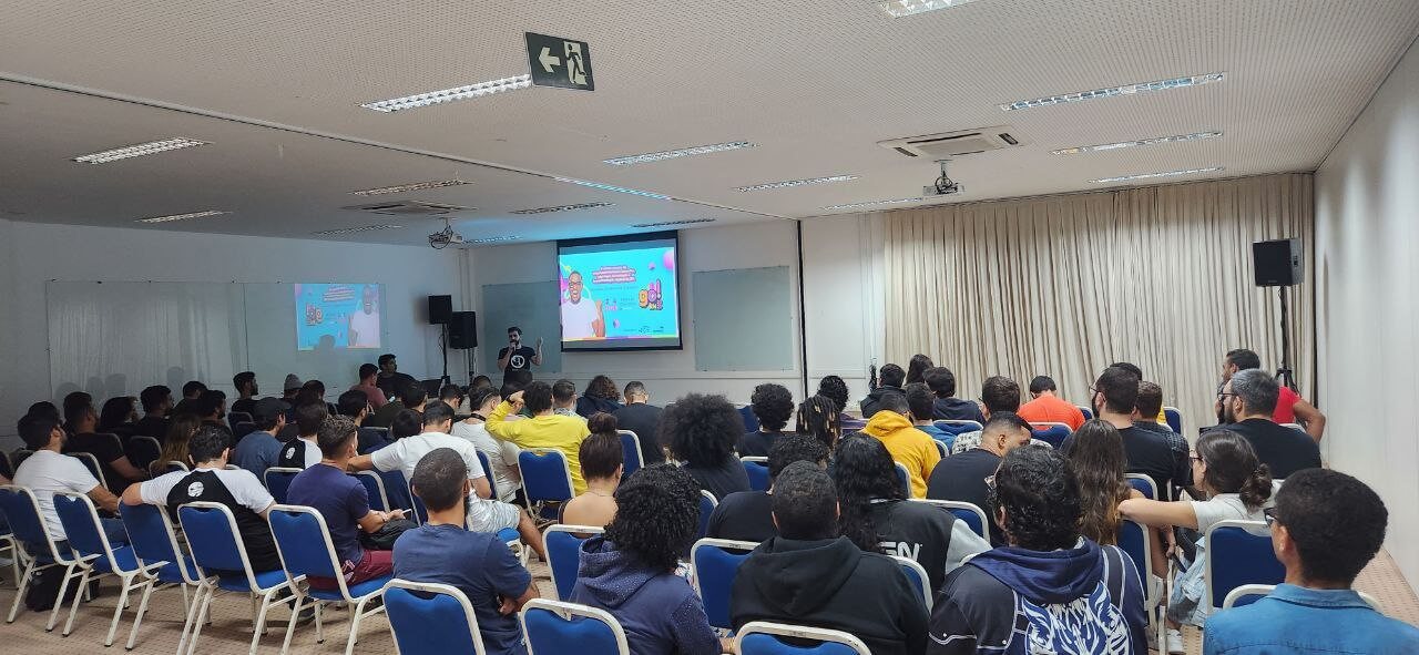 Foto do fundo sala mostrando todos os participantes assistindo a apresentação
